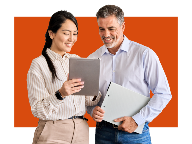 Two people standing looking at a tablet