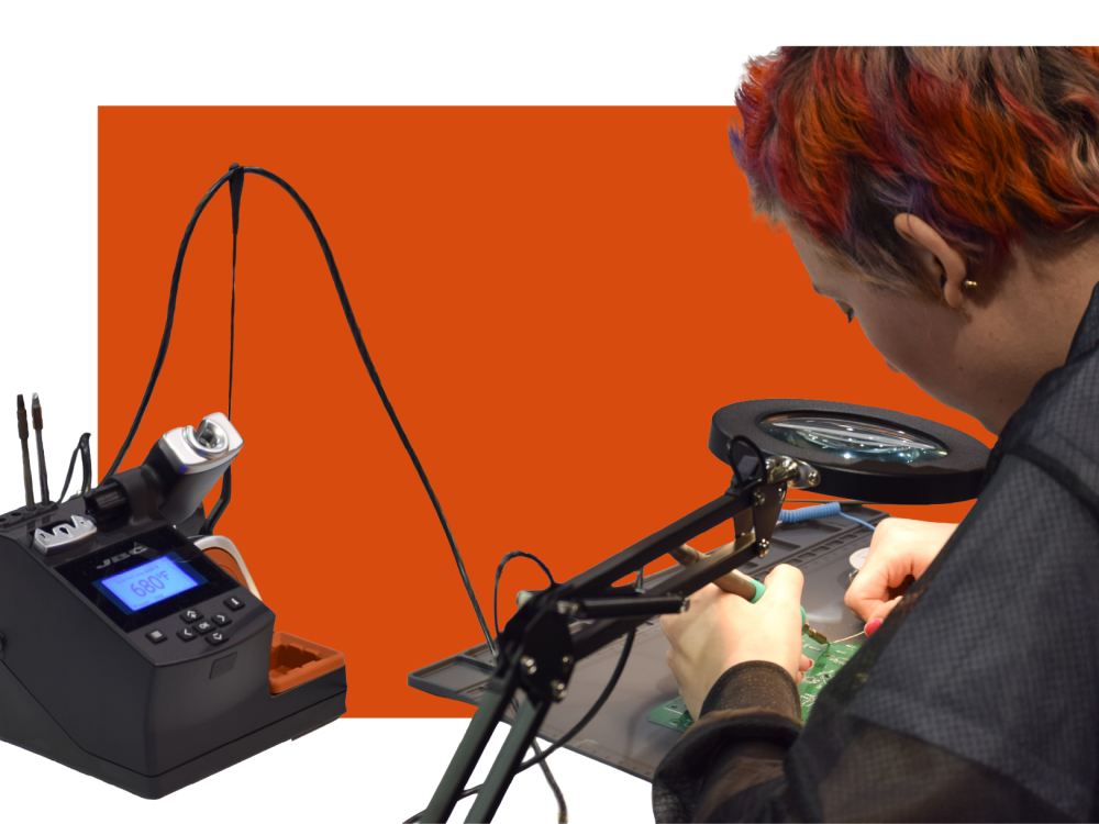Student working with a solder iron on a circuit board